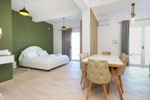 a living room with a table and a bed at Perla Luxury Apartment - Private Patio & Parking in Vlorë
