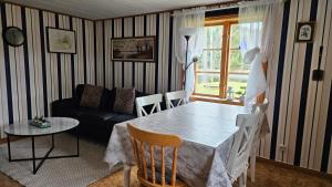 a living room with a table and a couch at Kilsborgs Gård - Lakehouse in Svanskog
