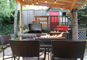 an outdoor patio with a grill and chairs and a television at Nestled Inn Bed and Breakfast in Victoria