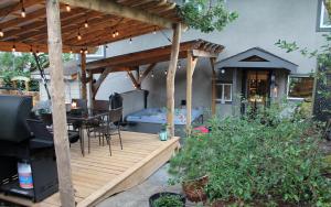 a wooden deck with a hot tub and a grill at Nestled Inn Bed and Breakfast in Victoria
