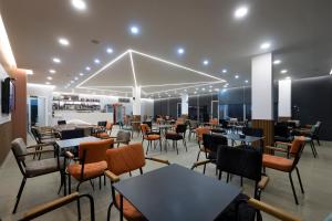 a restaurant with tables and chairs in a room at Bar Hotel Orgito in Lushnjë
