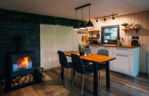 a kitchen with a wooden table and a fireplace at Naše chata in Ostrolovský Újezd