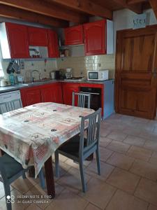 a kitchen with red cabinets and a table and chairs at Gite à Valleraugue Gard Cevennes in Valleraugue