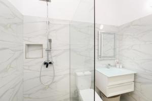 a bathroom with a shower and a toilet and a sink at Perla Luxury Apartment - Private Patio & Parking in Vlorë +58 photos