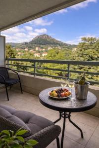 a table with a plate of fruit and wine glasses at Vue Panoramique Vence Balcon & Calme in Vence