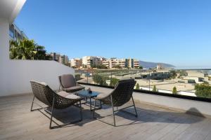 a patio with chairs and a table on a balcony at Perla Luxury Apartment - Private Patio & Parking in Vlorë