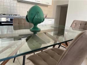 a glass table with a green vase on top of it at Maison RG in Torre Canne +5 photos