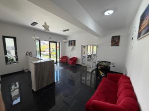 a living room with a red couch and red chairs at Pensiunea LOFT Căciulata in Caciulata