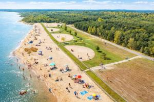 a group of people on a beach near the water at Floatinghouse Seestern in Klitten +17 photos