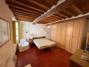 a bedroom with a bed and a chair in a room at La Benabbiana in Bagni di Lucca