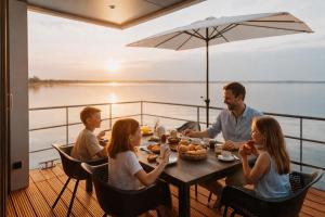 a group of people sitting around a table on a yacht at Floatinghouse Möwenblick - LP1 in Vetschau +6 photos