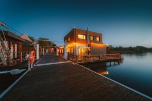 a dock with a building next to a body of water at Floatinghouse Möwe 1 - LP1 in Vetschau +10 photos