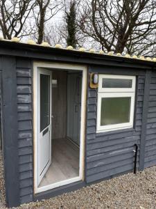 a small shed with a door and a window at Trevessa camping pod in Saint Erth
