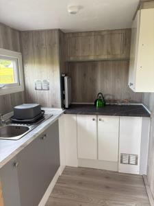 a kitchen with white cabinets and a sink at Trevessa camping pod in Saint Erth