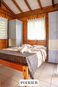 a bedroom with a bed in a wooden room at Gite de Paulo la source in Pointe-Noire +27 photos