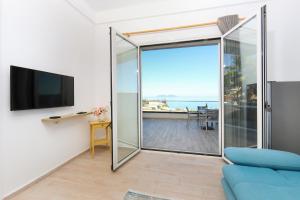 a living room with a sliding glass door with a view of the ocean at Perla Luxury Apartment - Private Patio & Parking in Vlorë