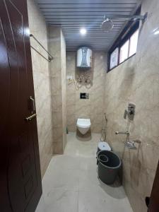 a bathroom with a toilet and a window at Laxman Homestay in Sarāhan