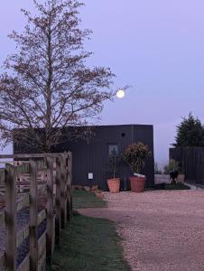 a fence with a tree in front of a building at The Lookout in Fenny Compton