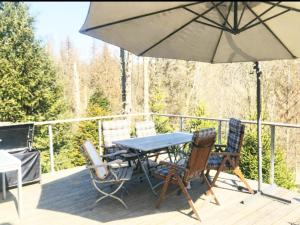 a table and chairs on a deck with an umbrella at Ferienhaus Allrode mit Wellness in Allrode