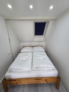 a small bed in a small room with a window at Lovely Home For You 2 in Biberach an der Riß