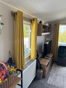 a living room with yellow curtains and a television at Ocean View At Glade in Bucks Mills