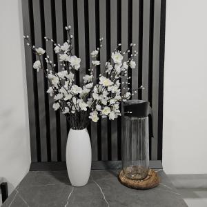 a white vase with white flowers on a table at Sarajevo s Secret -Airport Apartment East Sarajevo in Donje Mladice +16 photos