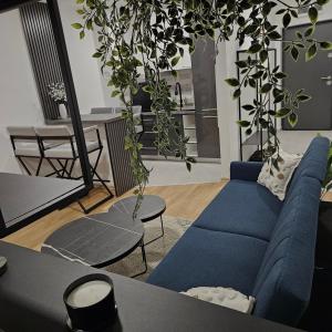 a living room with a blue couch and a table at Sarajevo s Secret -Airport Apartment East Sarajevo in Donje Mladice