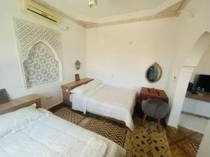 a bedroom with two beds and a table and a mirror at Hotel la renaissance tata in Tatta +41 photos