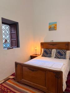 a bedroom with a wooden bed and a window at RiadTiznitSouss Votre oasis privée à Tiznit in Tiznit