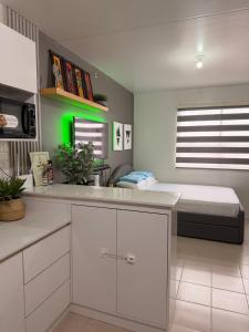 a kitchen with white cabinets and a bed in a room at Near Mactan Airport, Pool, Fast WiFi, Netflix & Disney in Lapu Lapu City +15 photos