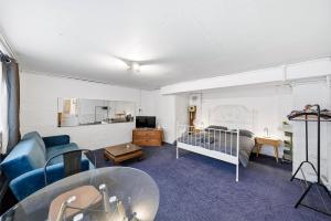 a living room with a couch and a bed at Lee Valley Lodge Ground Floor in Cheshunt