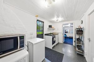 a kitchen with white appliances and a white ceiling at Lee Valley Lodge Ground Floor in Cheshunt +4 photos