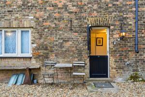 a brick building with a black door and a window at Lee Valley Lodge Ground Floor in Cheshunt