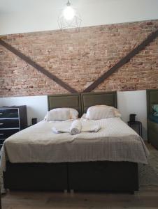 a bedroom with a bed with a brick wall at Apartament rodzinny SAKURA in Jędrzejów