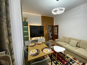 a living room with a table and a couch at Guest House Brahimasi in Çorovodë