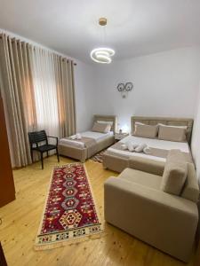 a living room with two beds and a couch at Guest House Brahimasi in Çorovodë