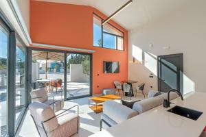 an open living room with orange walls and chairs at Black Mountain Villas in Kefallonia