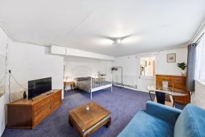 a living room with a blue couch and a tv at Lee Valley Lodge Ground Floor in Cheshunt