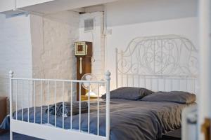 a bedroom with a white bed and a clock at Lee Valley Lodge Ground Floor in Cheshunt