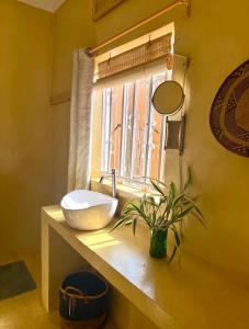 a bathroom with a bowl sink and a window at Villa Katwe in Masaka
