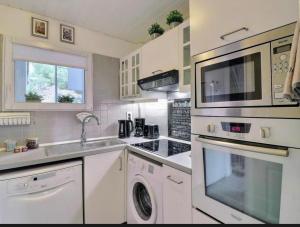 a kitchen with a stove top oven and a microwave at Le paradis bleu azur in Ensuès-la-Redonne