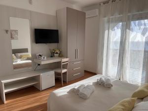 a bedroom with two beds and a desk and a mirror at BnB Nuova Vita in Paola