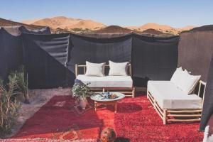 a tent with two chairs and a table in the desert at Kam Kam Dunes in Merzouga +27 photos