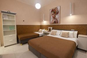 a hotel room with two beds and a desk and a bed at Il Vicoletto B&B - In pieno centro in Cirò Marina +67 photos