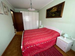 a bedroom with a bed with a red bedspread at La Chimera in Robilante