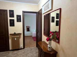 a bathroom with a mirror and a vase of flowers on a table at La Chimera in Robilante +3 photos