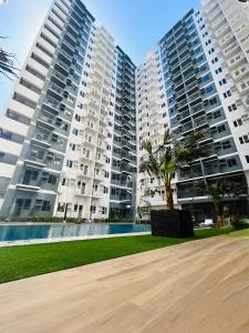 two large apartment buildings with a palm tree in the foreground at Mattys Crib Tower C Unit 204 in Iloilo City