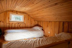 a small room with a bed in a wooden cabin at Лісова Хатка in Parowa