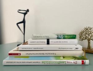 a stack of books sitting on top of a table at Weiher Apartment mit Terrasse & Parkplatz in Kulmbach