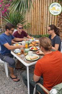 a group of people sitting around a table eating food at Paracas Desert Lodge&Tours in Paracas